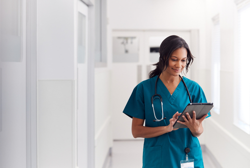 woman wearing teal scrubs with stethoscope and clip board