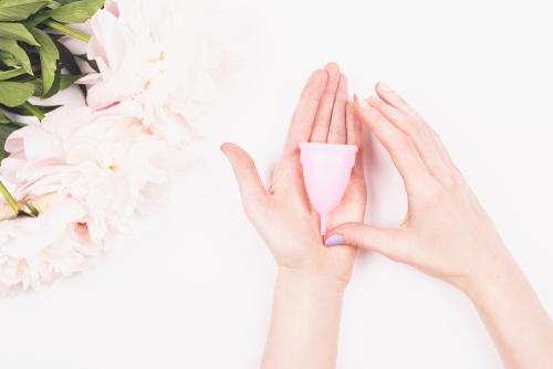 open hand holding pink menstrual cup