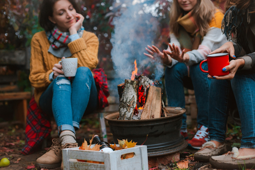 women sitting around a campfire