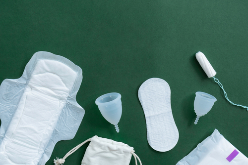 sanitary pads, menstrual cups, tampons on a green background
