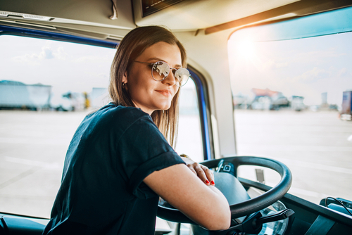 young woman in sunglasses and t-shirt driving a truck